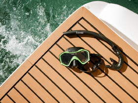 A snorkel mask and snorkel resting on the deck of a boat, ready for underwater adventures — perfect for exploring vibrant marine life.