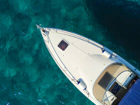 Aerial view of a sleek boat gliding over crystal-clear waters, showcasing its elegant design and perfect for a day on the water.