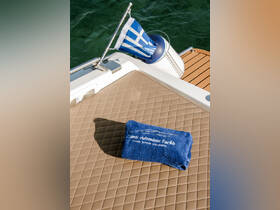 A neatly folded blue towel rests on the deck of a yacht, showcasing the luxurious experience offered by private yacht charters.