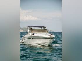A sleek speedboat navigates through clear waters, showcasing its design and performance on a sunny day.