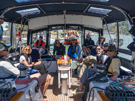 A lively group enjoys their time aboard a boat, showcasing camaraderie and fun in a comfortable interior setting — perfect for social gatherings on the water.