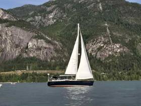 A beautiful sailboat glides through calm waters, framed by stunning mountainous scenery — perfect for sailing enthusiasts and nature lovers.