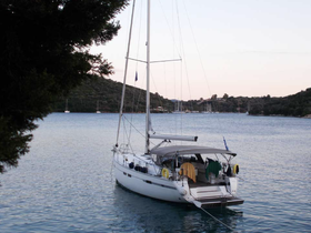 A serene view of a sailboat docked in calm waters, surrounded by lush greenery and distant hills, perfect for showcasing tranquil boating experiences.