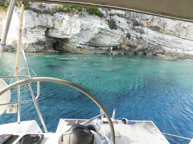 A serene view from the helm of a catamaran, showcasing clear turquoise waters and rocky cliffs, perfect for exploring hidden coves.