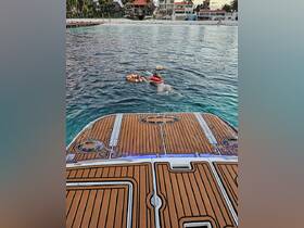 A child swims with a life ring in the clear waters, showcasing fun water activities and safety on a boating adventure.