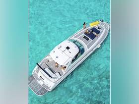 Aerial view of a group enjoying a sunny day on a yacht, lounging on the deck above crystal-clear turquoise waters — perfect for summer adventures and relaxation.