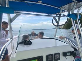 A group of friends enjoys a day on the water, gathered around the helm of a boat, perfect for exploring scenic destinations.
