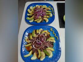 A beautifully arranged platter featuring fresh avocado and onions, perfect for onboard dining experiences. Ideal for catering on boat trips.