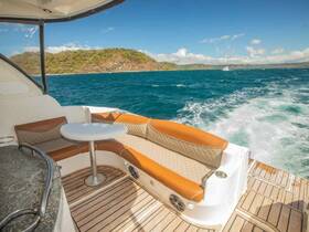 A cozy seating area inside a boat, featuring plush cushions and a table, perfect for relaxing while cruising on the open water.
