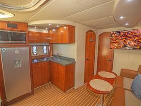 A well-appointed boat interior featuring a modern kitchen area with sleek cabinetry, a comfortable seating space, and large windows for natural light — perfect for relaxing and dining while on the water.