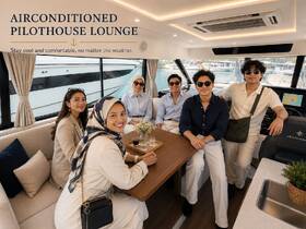Guests enjoy the air-conditioned pilothouse lounge of a luxury boat, showcasing a stylish and comfortable interior perfect for relaxation on the water.
