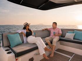 A couple enjoys cocktails on a stylish boat at sunset, creating the perfect ambiance for romantic getaways or special celebrations on the water.