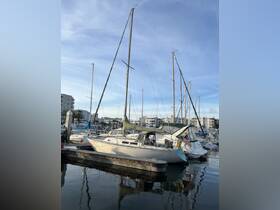 A beautiful sailboat docked at a marina, surrounded by other vessels under a clear blue sky — perfect for sailing enthusiasts and waterfront views.