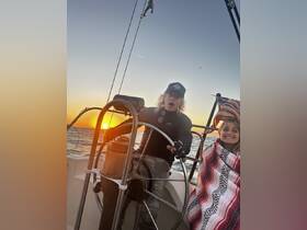 A couple enjoys a beautiful sunset while sailing, capturing the joy of the moment on the water.