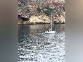 A serene sailing experience with a boat anchored near a stunning rocky coastline, showcasing the beauty of nature and the joy of being on the water.