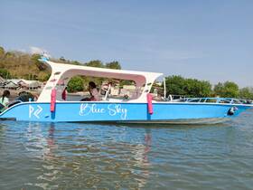 A vibrant blue boat named 'Blue Sky' is docked, showcasing its unique design against a scenic backdrop. Perfect for exploring coastal waters.