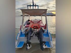 A view of a colorful boat with outboard motors, docked at sunset, showcasing its design and structure against a serene backdrop.