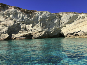 A stunning view of a rocky coastline with crystal-clear waters, perfect for exploring by boat or enjoying a day at the beach.