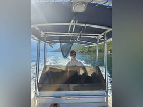 A smiling captain navigates the boat from the helm, showcasing the interior setup and stunning views of the surrounding landscape.
