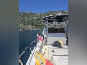 A child and an adult enjoy a fishing trip on a boat, surrounded by stunning mountainous scenery — a perfect family adventure on the water.