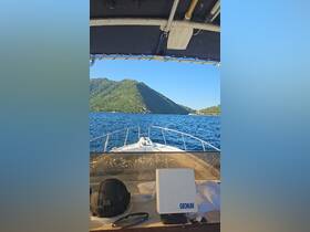 A view from the front of a boat navigating through calm waters, showcasing the scenic mountainous landscape ahead — perfect for exploring coastal destinations.