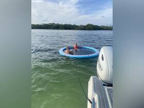 Two friends enjoy a relaxing day on a floating mat in the water, perfect for summer fun and leisure activities.