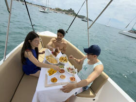 A group enjoys a delicious spread of snacks aboard a boat, perfect for a relaxing day on the water.