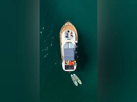 Aerial view of two people sunbathing on a boat with paddleboards nearby, showcasing a perfect day on the water.