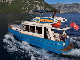 A lively group enjoys their time aboard a stylish boat, complete with paddleboards, as they cruise through beautiful waters — perfect for summer adventures.