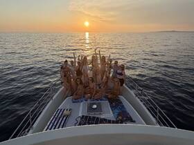 A lively group of friends celebrates on the deck of a yacht at sunset, capturing the essence of summer fun and unforgettable memories on the water.