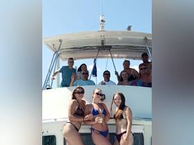 A lively group of friends enjoys a sunny day on the boat, celebrating together with drinks and smiles — perfect for summer outings and memorable gatherings.