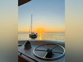 A serene sunset view featuring a sailboat anchored in calm waters, captured from the deck of another vessel — perfect for tranquil evening cruises.