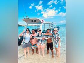 A cheerful group poses with their catch after a successful fishing trip, showcasing the fun and camaraderie of a day on the water.