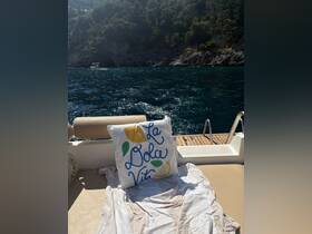 A cozy cushion with the phrase 'La Dolce Vita' rests on a boat's seating area, perfect for relaxing and enjoying the serene waters.