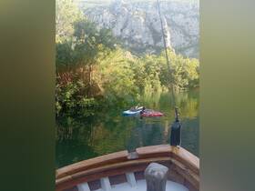 Two children enjoy a relaxing kayaking experience on a serene river, surrounded by lush greenery and stunning cliffs — a perfect getaway for family adventures.