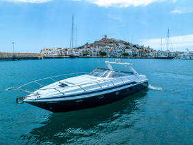 A sleek speedboat navigates the turquoise waters near a picturesque coastal town, showcasing the perfect blend of adventure and relaxation on the water.