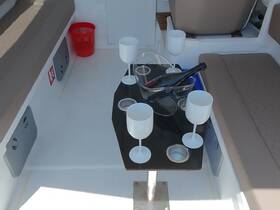 A stylish setup featuring cocktails and a bottle of champagne on a sleek table inside the boat, perfect for entertaining guests.
