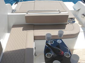 Luxurious lounge area on a boat featuring plush seating and a stylish table with champagne, perfect for relaxing and enjoying the sun on the water.
