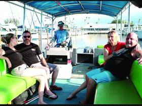 A cozy interior shot of a boat featuring guests relaxing on comfortable seating, showcasing the inviting atmosphere perfect for social gatherings on the water.
