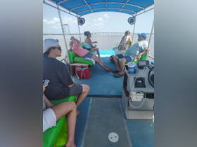 Guests relax inside a pontoon boat, enjoying the spacious seating and scenic views — perfect for leisurely outings on the water.