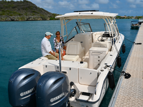 A couple enjoys a relaxing moment aboard a Yamaha boat at the dock, surrounded by serene waters and lush greenery — perfect for a day of leisure on the water.