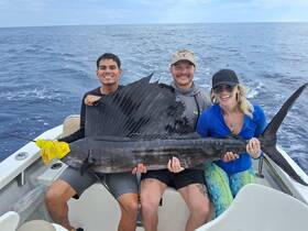 A group celebrates their impressive catch while fishing in the ocean, showcasing the thrill of deep-sea fishing adventures.