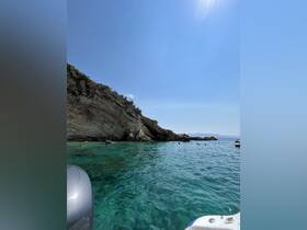 A beautiful coastal scene with clear turquoise waters and people swimming near the rocky shoreline — perfect for a day of adventure and exploration.