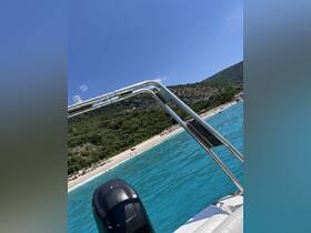 A scenic view from a boat overlooking a beautiful beach with sunbathers enjoying the turquoise waters — perfect for summer outings and coastal adventures.