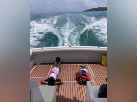 Two children relax on the deck of a boat, enjoying the ocean breeze and the beautiful turquoise waters — a perfect moment for family fun on the water.