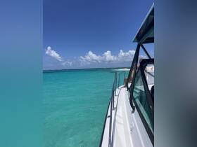 A scenic view from the side of a boat cruising through crystal-clear turquoise waters, showcasing the beauty of the ocean and a relaxing day on the water.