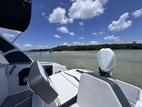 A scenic view from a boat with a group of people enjoying the beach in the background, perfect for a day of fun on the water.