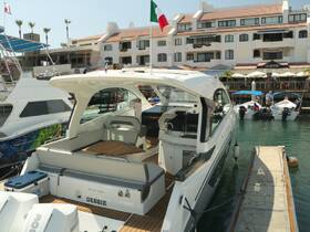 A sleek Beneteau yacht named 'DEBBIE' docked at a marina, showcasing its elegant design and inviting outdoor seating area.