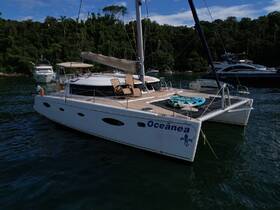 A sleek catamaran named 'Oceânea' docked in tranquil waters, showcasing its spacious deck and inviting atmosphere for a perfect day on the water.