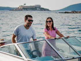 A cheerful couple enjoys their time on a boat, showcasing the joy of outdoor adventures on the water.